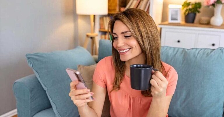 Profissional sorridente usando smartphone para demonstrar uma mensagem de saudação para whatsapp eficaz para atendimento ao cliente empresarial.