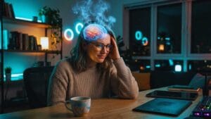 Mulher empreendedora em um home office com o cérebro brilhando e emitindo fumaça de alívio após descobrir o método exato para criar ebook com inteligência artificial grátis, técnica de automação que domina o mercado digital no Rio de Janeiro.